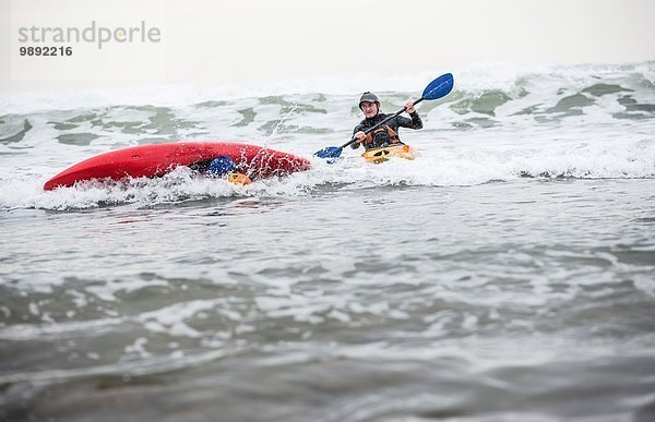 Erwachsener Mann  der im Kajak ins Meer gefallen ist.