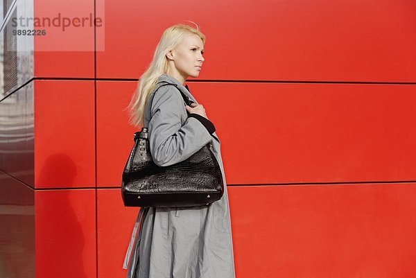 Geschäftsfrau  Spaziergang im Freien neben rotem Gebäude