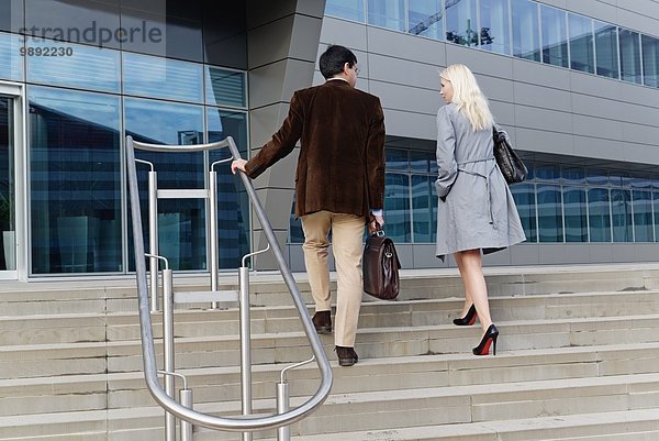 Geschäftsmann und Geschäftsfrau  gemeinsam die Treppe hinaufgehen  Rückansicht