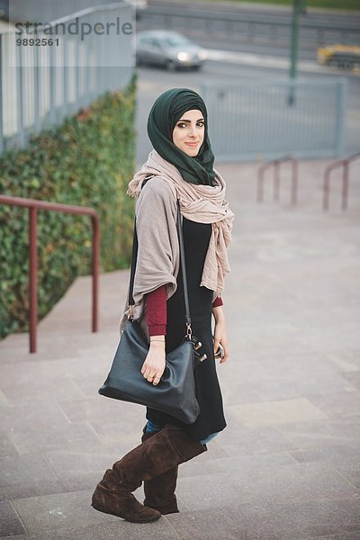 Porträt einer jungen Frau mit Hijab auf der Treppe