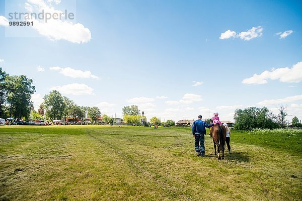 Rückansicht des jungen Mannes und zweier Mädchen auf dem Feld  Rezh  Gebiet Swerdlowsk  Russland