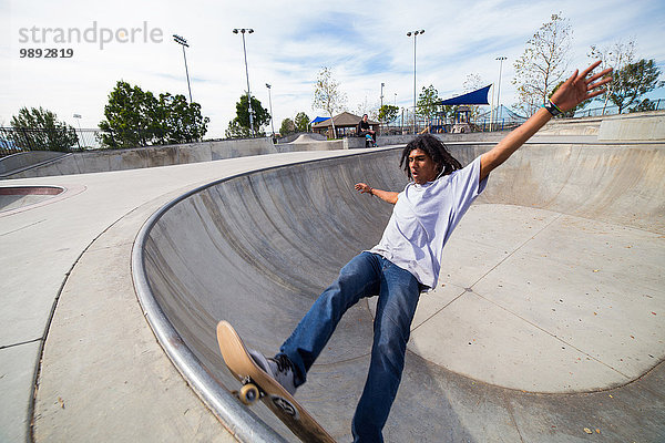Junger Mann beim Skateboarden auf der Skateboard-Park-Wand