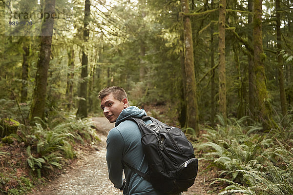 Junger Mann im Wald mit Rucksack