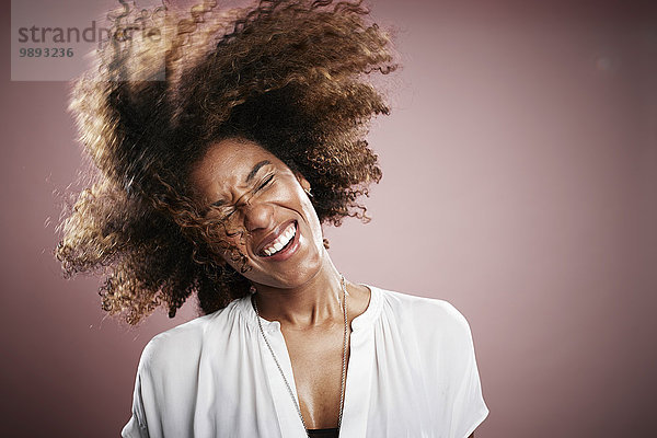 Porträt einer jungen Frau  die Haare schnippt  lächelnd