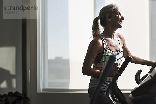 Reife Frau beim Training auf dem Fitnessgerät