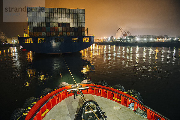 Schlepper manövriert Frachtschiff im Hafen bei Nacht  Tacoma  Washington  USA