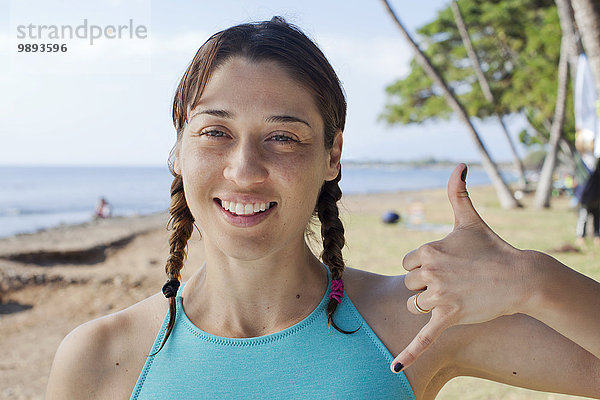 Frau macht Handbewegung am Strand