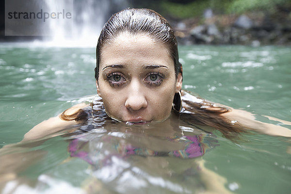 Schwimmende Frau  Wasserfall im Hintergrund