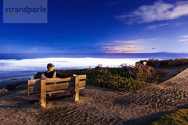 Mann auf Bank sitzend  mit Blick auf die Aussicht  Del Mar  Kalifornien  USA