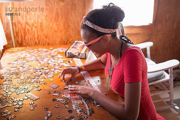 Ein junges Teenagermädchen macht ein Puzzle in den Sommerferien.