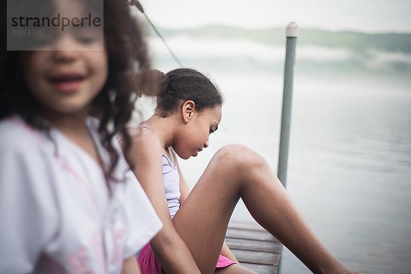 Schwestern  die im Sommerurlaub am Lake George  New York  USA  am Dock sitzen