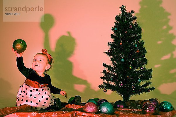 Kleines Mädchen mit einer Weihnachtskugel