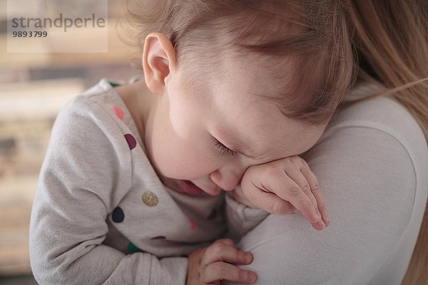 Kleinkind Mädchen weint auf Mutter's Schulter