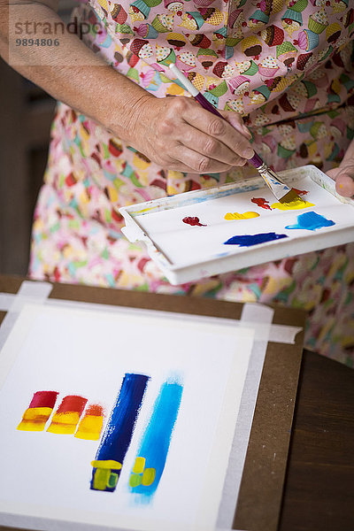 Seniorin malt ein abstraktes Bild  Nahaufnahme