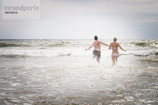 Mexiko  Riviera Nayarit  junges Paar  das ins Meer läuft
