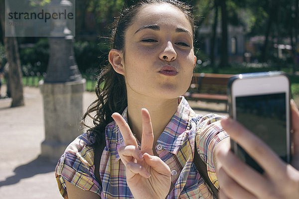 Junge Frau  die einen Selfie mit Smartphone nimmt