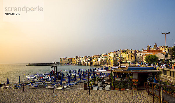 Italien  Sizilien  Cefalu  Blick auf mittelalterliche Häuser mit Strand im Vordergrund bei Abenddämmerung