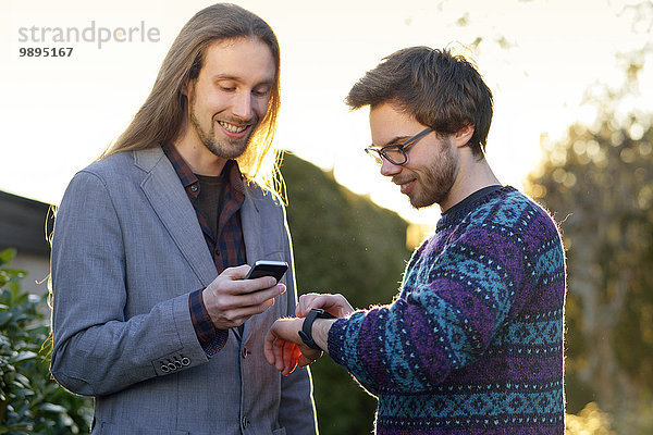Zwei Hipster mit Smartwatch und Smartphone