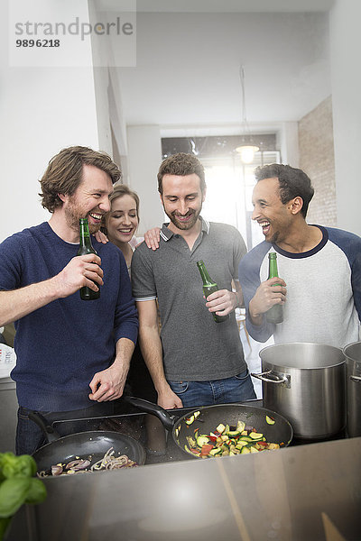 Glückliche Freunde beim gemeinsamen Kochen