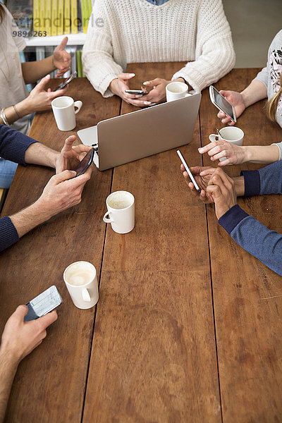 Gruppe von Freunden mit Smartphones in einer Cafeteria