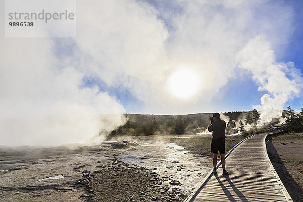 USA  Wyoming  Yellowstone Nationalpark  Lower Geyser Becken  Touristen fotografieren Dampf der Geysire am Morgen