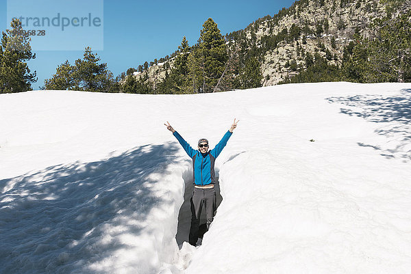 Spanien  Katalonien  glücklicher Mann in einem Loch im Schnee in den Pyrenäen