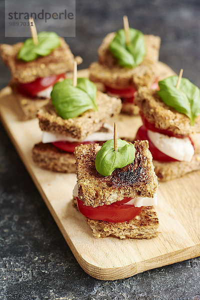 Caprese-Salat auf Toast mit Tomaten  nicht milchigem Mozarella-Käse und Basilikumblatt