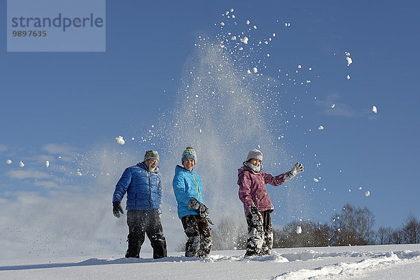 Vater und zwei Kinder haben Spaß im Schnee