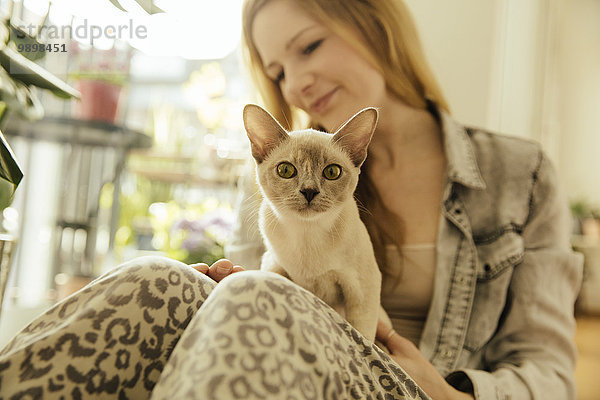 Frau mit burmesischer Katze zu Hause