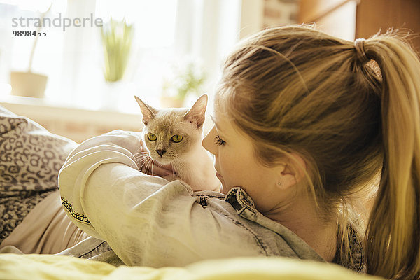 Frau mit burmesischer Katze zu Hause