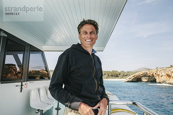 Spanien  Mallorca  Porträt eines lächelnden Mannes auf dem Boot