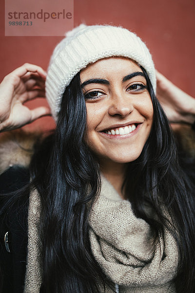 Porträt einer glücklichen jungen Frau mit Wollmütze