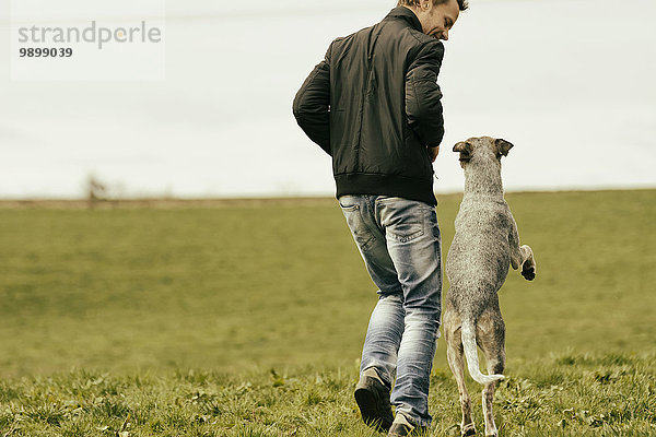 Frau beim Training mit Hund auf der Wiese