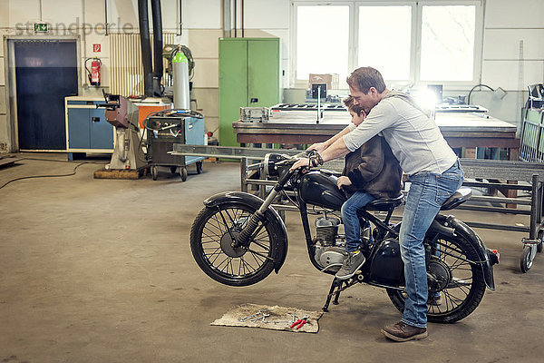 Vater und Sohn pflegen Vintage Moped