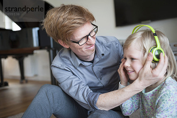Lächelnder Vater und Tochter mit Kopfhörer
