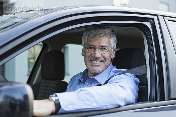 Porträt eines lächelnden Geschäftsmannes im Auto