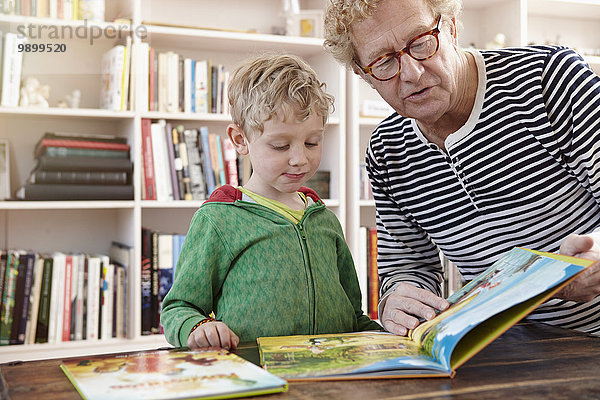 Großvater und Enkel lesen gemeinsam Kinderbuch