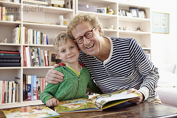 Großvater und Enkel lesen gemeinsam Kinderbuch