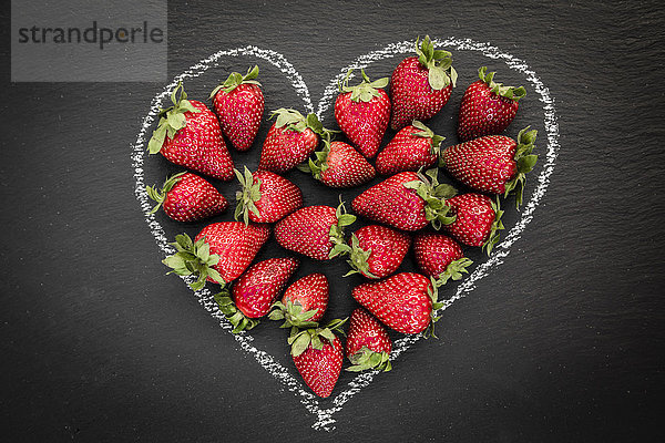 Erdbeeren in Form eines Herzens auf Schiefer