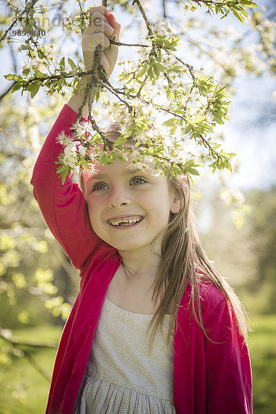 Porträt eines lächelnden Mädchens mit blühendem Zweig