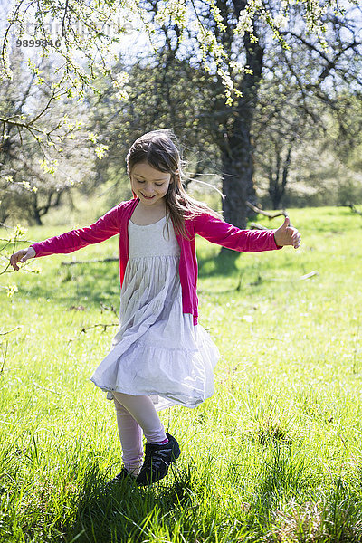 Mädchen beim Tanzen auf einer Wiese im Frühling