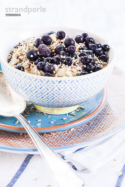 Veganes Superfood-Frühstück mit Brei  Mandelmilch  Heidelbeeren und gerösteter Quinoa