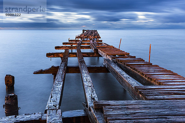 Chile  Punta Arenas  gebrochener alter Steg bei Sonnenuntergang