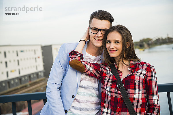 Deutschland  Mannheim  lächelndes junges Paar auf der Brücke