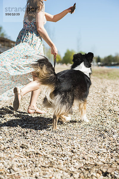 Frau beim Spaziergang mit Hund im Sommer