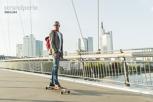 Deutschland  Frankfurt  Mann Skateboarding auf der Brücke