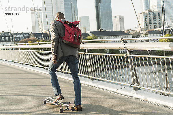 Deutschland  Frankfurt  Mann Skateboarding auf der Brücke