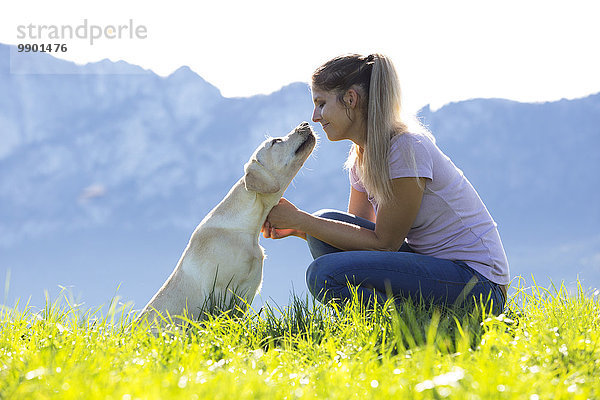 Österreich  Mondsee  Frau mit Labrador Retriever auf Alpweide