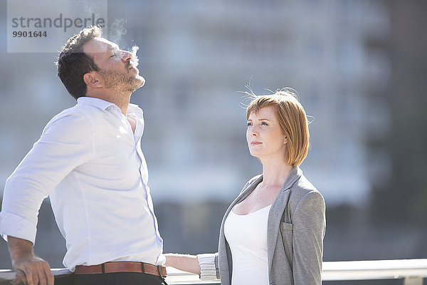 Geschäftsleute  die eine Pause machen  Mann  der eine Zigarette raucht.