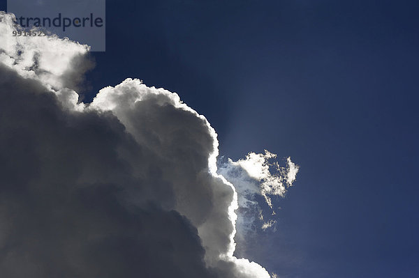 Regenwolken  Nimbostratus  vor blauem Himmel mit hellem Sonnenrand